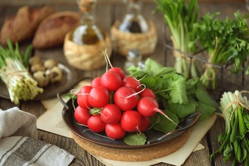 Fresh spring radish with wild garlic parsley and quail eggs on a wooden background. Ingredients for the salad.