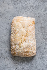 Homemade fresh ciabatta on grey stone table. View from above. Vertical.