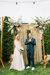 beautiful boho style wedding ceremony. The bride in a beautiful dress and the groom in a classic suit