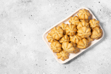 Shortbread with poppy seeds in a white ceramic plate on the gray kitchen table. Shortbread. Space for text	