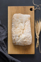 Homemade fresh ciabatta on black table. View from above. Vertical.