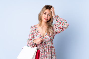 Teenager Russian girl with shopping bag isolated on blue background with an expression of frustration and not understanding