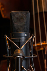A large diaphragm condenser microphone in a suspension cradle is used to record double bass in a...