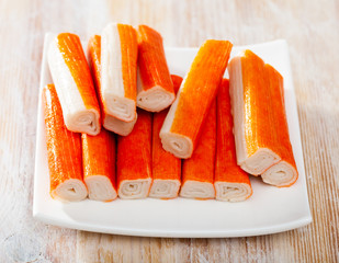 Many crab sticks on white surface
