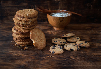 Oat cookies and flakes on a dark wooden table