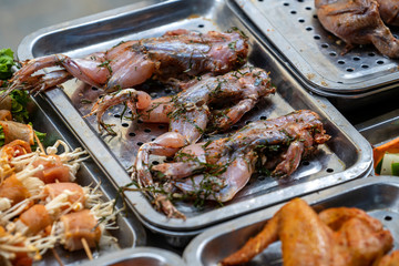 Marinated frogs on the counter of a street restaurant for grilling in mountain village Sapa, north Vietnam, close up