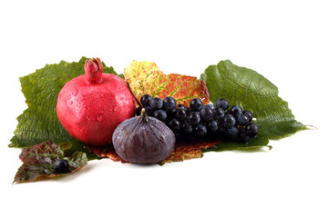 Southern fruits on autumn leaves. Grape, pomegranate, fig