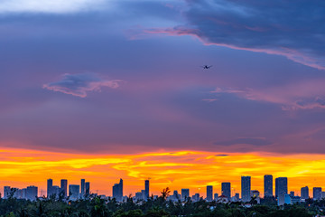 Obraz premium Plane landing over Miami city at sunset