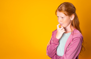 A Red Hair Teenager Girl Nervously Bites Her Nails Stressed