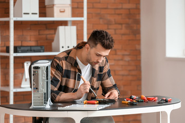 Electronic technician repairing computer in service center