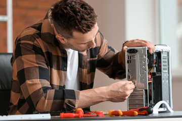 Electronic technician repairing computer in service center