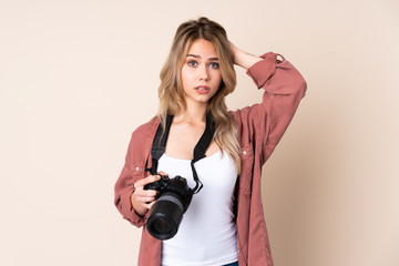 Young photographer girl over isolated background frustrated and takes hands on head
