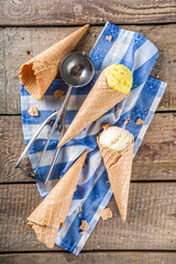 Set of various homemade colorful ice cream with icecream waffle cones on wooden background, copy space top view