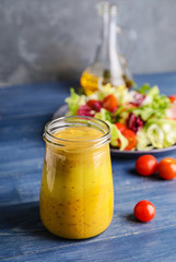 Jar of tasty honey mustard sauce on wooden table
