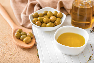 Bowl of tasty olive oil on table