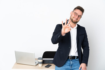 Russian man in a office isolated on white background happy and counting three with fingers