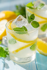 Lemonade and ingredients on blue wood background, copy space