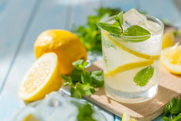 Lemonade and ingredients on blue wood background, copy space