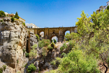 Stone medieval bridge in the city of Ronda Spain view from the side, view on the rocks and gazebo...