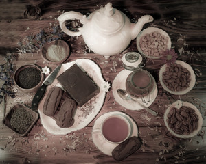 Tea table with vintage mother-of-pearl tea pot, cups and  saucers, flowers, pecans, cashews,...
