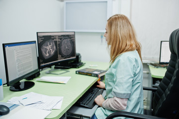 Medical theme. Doctor in the mri office at diagnostic center in hospital, sitting near monitors of computer.