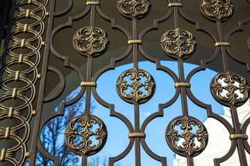 The texture of the fragment of the fence. Detailed view of the decorated patterned cast iron fence....