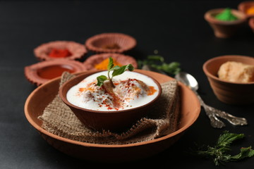 Fototapeta na wymiar Dahi vada (Deep fried balls served with curd), thandai are well known indian Holi snack. (Holi Concept)