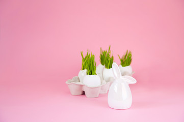 Easter concept with eggs and bunny on a pink background. Eggshell grass, spring, Easter. Festive concept close-up and copy space on a pink background.