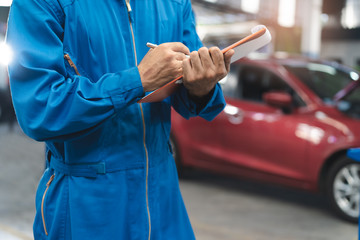 close up view mechanic checking car maintenance list jobs and notes detail of repairs part in the auto service shop.