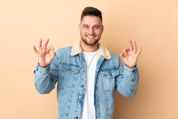 Fototapeta premium Russian handsome man over isolated background showing ok sign with two hands