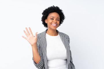 African american woman with blazer over isolated white background saluting with hand with happy expression