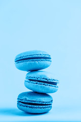 Colorful macaroons on a classic blue background, close-up, Flatley with copy space