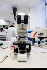 Close-up shot of microscope with metal lens at laboratory.  Chemistry and science research concept background.
