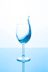 glass of red wine with wave on light background, classic blue concept whith copy space. Vertical orientation.