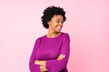 African american woman over isolated pink background with arms crossed and happy