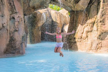 Child on water slide at aquapark. Summer holiday.