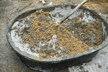 Mixing sand and cement by hand.