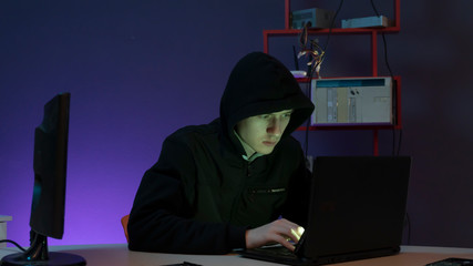 hacker in the hood near the computer
