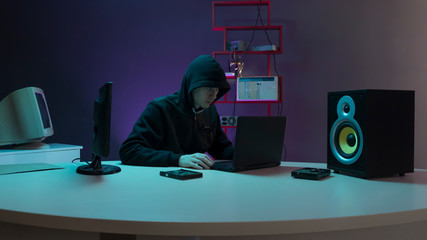 hacker in the hood near the computer