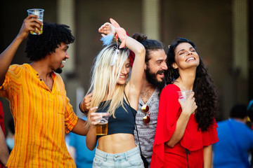 Group of young happy friends enjoying outdoor music festival