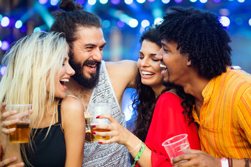 Group of happy friends hanging out and enjoying drinks, festival