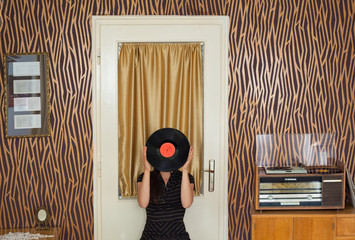 Young woman plays music in her mid-century home interior
