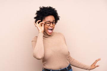 African american woman over isolated background with glasses and surprised