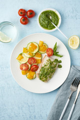 Keto dinner with white fish. Oven baked fillet of cod, pike perch with vegetables and pesto sauce