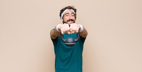young cool bearded man at gym with a dumbbell. sport concept