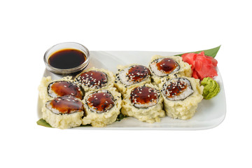 Sushi, rolls, uramaki, tempura with teriyaki sauce, sesame, raw seafood, soy sauce, marinated ginger and wasabi. Food on a banana leaf, on plate, white isolated background, side view