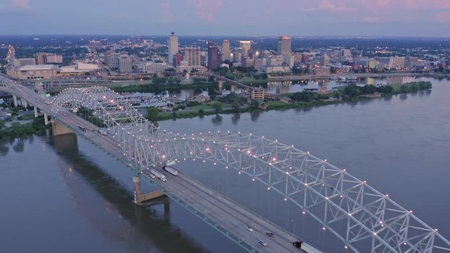 Aerial flying over traffic on the Hernando de Soto Bridge that crosses the Mississippi River at night. In the background is downtown Memphis, Tennessee, USA