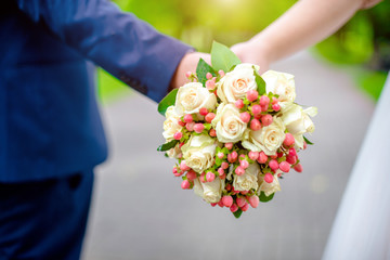 The bride and groom are holding a wedding bouquet