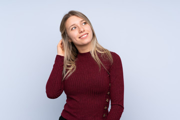 Young blonde woman over isolated blue background thinking an idea