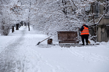 Janitor is cleaning snow in the city after snowfall.